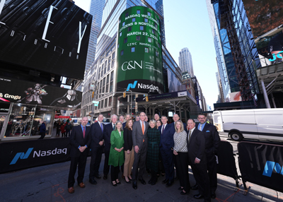 C&N Team in front of Nasdaq sign